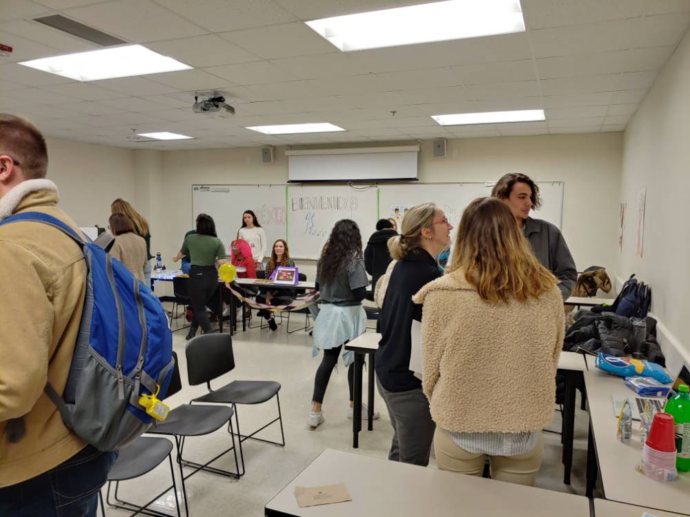 Students and professors discussing art in Spanish in a classroom